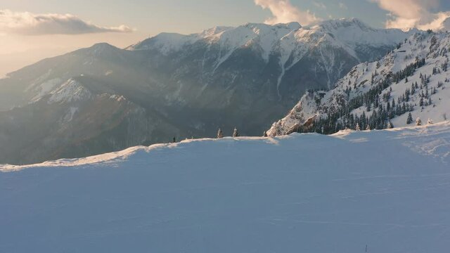 Hiker walking on a mountain ridge on snow in winter, Aerial shot with drone.