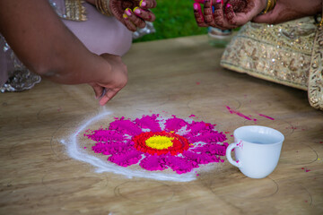 Obraz na płótnie Canvas Indian pre wedding Mayian Haldi ceremony bright traditional mosaic and powder close up 