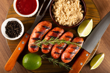 Grilled barbecue sausages on wooden background.