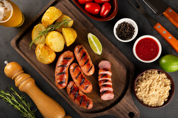 Grilled barbecue sausages on dark background.