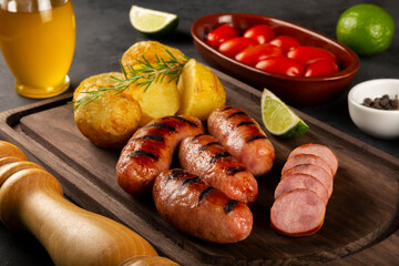 Grilled barbecue sausages on dark background.