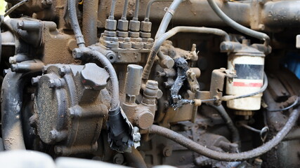 Hydraulic oil tank on an old engine. Heavy equipment gets dirty through heavy use with dusty engines and lack of maintenance. Choose subject and focus closer.