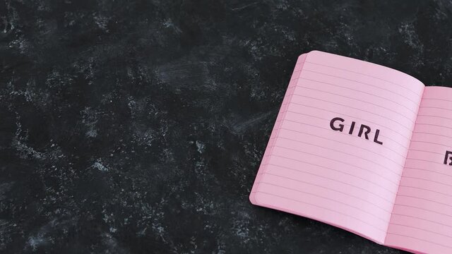equal opportunities Girl Boss text on top of pink notebook on black background
