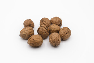 Stack of walnuts piled together isolated on white background with shadows. Close up view, horizontal shot.
