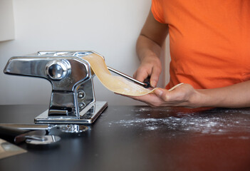 rolling the pasta dough with the machine at home. making pasta