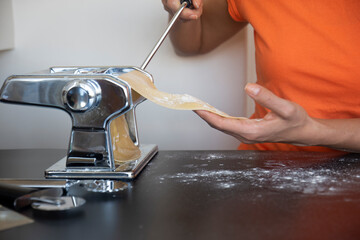 roll out the pasta dough with the machine at home. making pasta