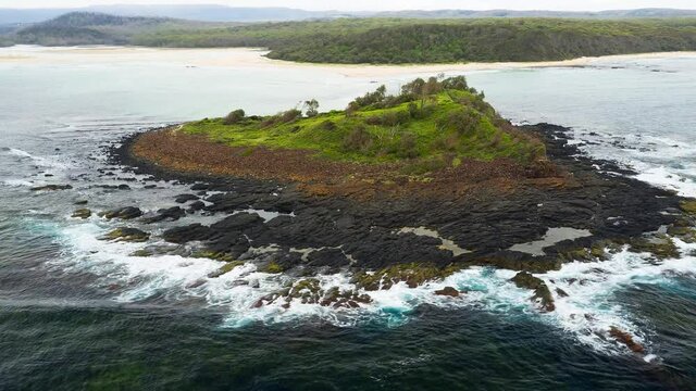 Hyperlapse of the waves crashing onto green island on south coast of Australia near the town of Cunjurong Point surrounded by the Conjola National Park