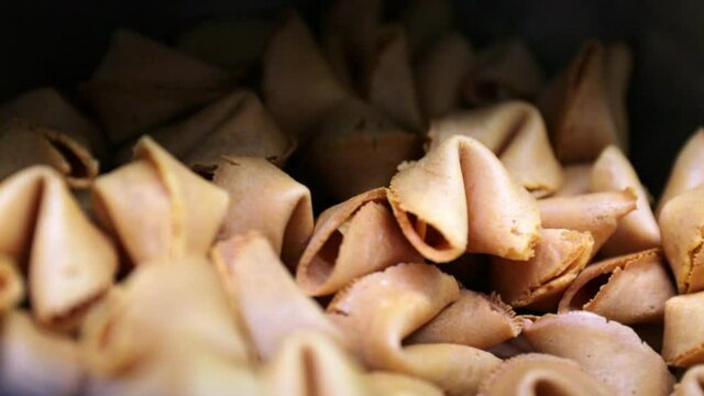 Close-up panning shot of fresh fortune cookies pile at store - San Francisco, California