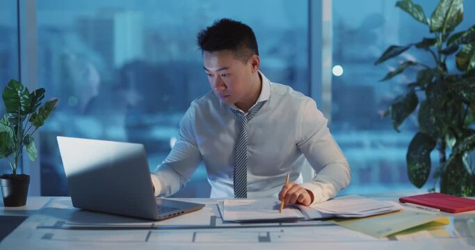 Indoor portrait of corporate leader chinese financial manager reading and examining document papers posing at camera. Business person. Ethnicity.