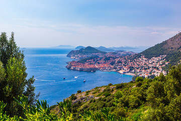 Naklejka na ściany i meble Panoramic view of Old Town medieval Ragusa and Dalmatian Coast of Adriatic Sea in Dubrovnik. Blue sea with white yachts, beautiful landscape, aerial view, Dubrovnik, Croatia