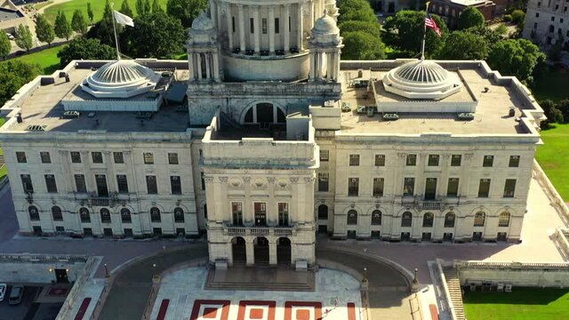 Aerial tilt down shot of state government office in city on sunny day, drone flying over tourists at famous landmark - Providence, Rhode Island
