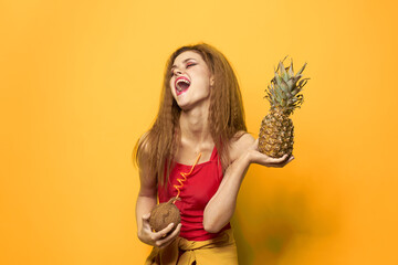 woman with pineapple and coconut cocktail exotic fruits summer lifestyle yellow background