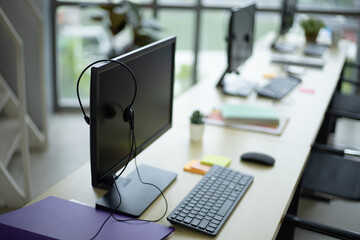 Side view of computers and headset on desk at call center training center