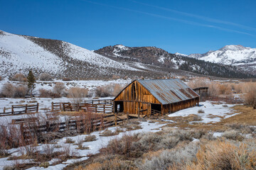 Rustic wooden barn in the Eastern Sierra Nevada mountains during winter.