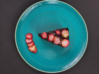chocolate cake with strawberries in turquoise dish