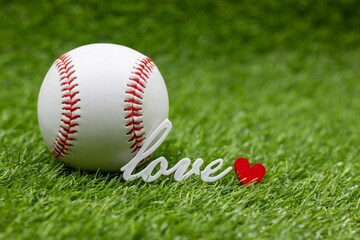 Baseball is on green grass with love word 