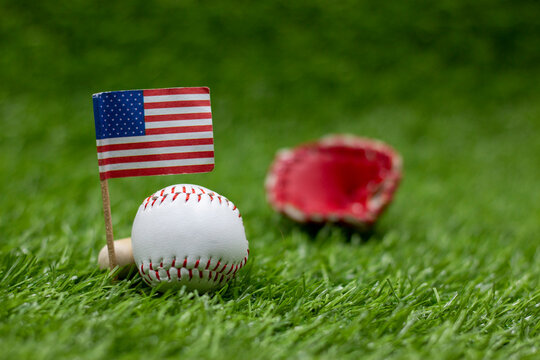 Baseball with flag of America on green grass