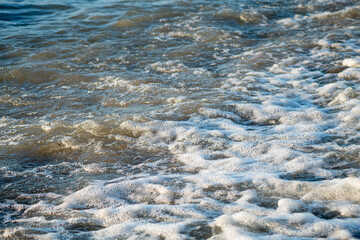 White waves foaming in the blue water