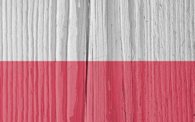 The flag of Poland on dry wooden surface, cracked with age. Light pale faded paint. Background, wallpaper or backdrop with Polish national symbol. Old wood. Hard sunlight with shadows