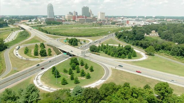 Aerial: Freeway traffic interchange and the Winston-Salem city skyline, North Carolina, USA