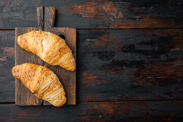 Tasty buttery croissants, on old dark  wooden table background, top view flat lay, with copy space for text