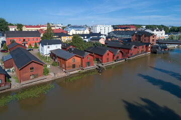Fototapeta na wymiar Old red barns on the banks of Porvoonjoki river on a sunny July day (aerial survey). Symbol of the city of Porvoo