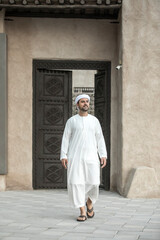 arab man in traditional clothing coming out of a door