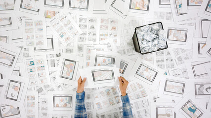 The hands of men put the sheets on the table of many paper with a storyboards
