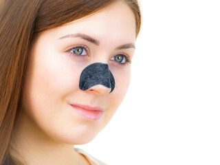 Woman applying pore strips on nose