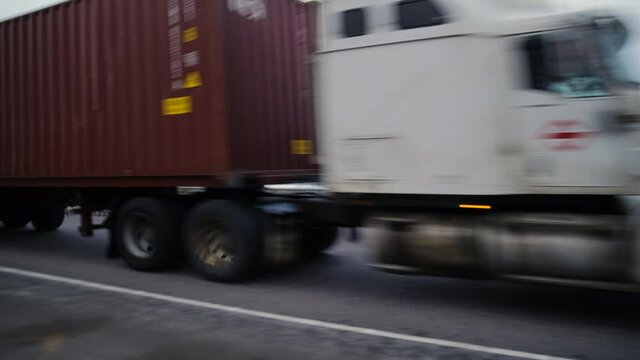 A truck is speeding along the Autobahn at great speed. A trucker is driving along the high-speed road. A large truck with a burgundy body is driving along the Autobahn at high speed.