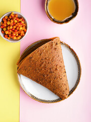 Fruit pastille of sea buckthorn and honey, fresh buckthorn. Russian pastila. Healthy raw vegan snack. Organic super food sweets. Vegetarian dietary food. Fruit leather. Sweets candy roll.  Copy space.