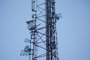 Scaffolding with antennas on a blue background.Photo during the day.