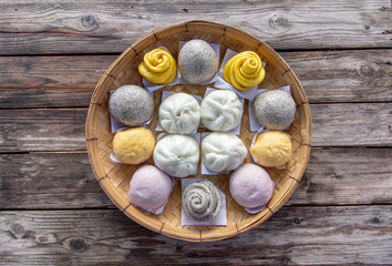 Steamed bun,yellow Steamed bun ,purple Steamed bun on bamboo basket in morning top view wooden background