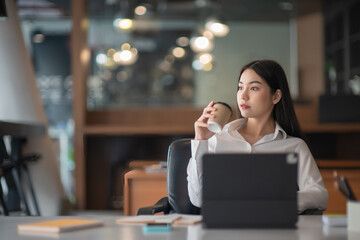 Businesswoman having tea or coffee in home office.