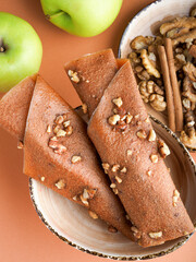 Fruit pastille of apples, walnuts and cinnamon. Russian pastila. Healthy raw vegan snack. Organic super food sweets. Vegetarian dietary food. Fruit leather. Apple sweets candy roll. Space for text. 
