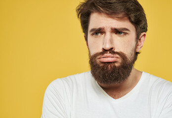 Obraz premium Portrait of a nice guy sad face yellow background cropped view