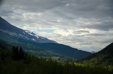 Naklejka na ściany i meble Alaskan mountains with clouds and blue sky