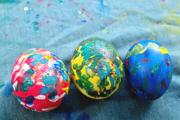 Easter Sunday egg painting activity concept. Kids hands painting colorful eggs on table flat lay.