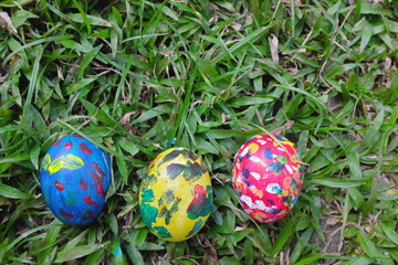 Easter Sunday concept. Three colorful eggs hidden on grass garden with copy space.