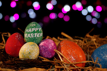 beautiful colorful Easter eggs lie on the straw with a shiny background