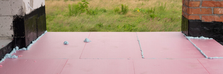 Construction foam between pink extruded styrofoam sheets