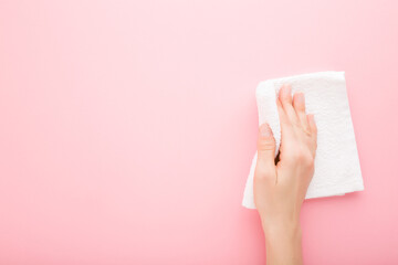 Young adult woman hand holding white rag and wiping table, wall or floor surface in kitchen,...