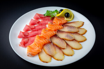 Fish platter on the white plate and black background isolated.