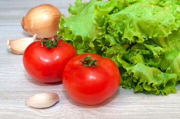 Red tomatoes and lettuce on the table. Vegetarian healthy food