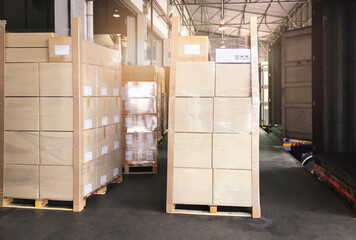 Stacked of cardboard on pallet rack. Cargo trailer truck parked loading at dock warehouse. Cargo shipment. Freight truck transportation. Logistics