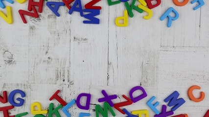 Word - Background - in bright colorful alphabet letters with top and bottom matching border on grey wood background viewed from overhead. Stop motion, top view, copy space