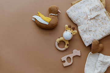 Bib and wooden toys. Set of baby stuff and accessories for newborn on brown background. Baby shower or baby care  concept. Fashion newborn. Flat lay, top view - 418473759