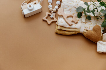 Newborn baby accessory and wooden toys in a box on a brown background. Top view, flat lay. Baby shower. Newborn stuff