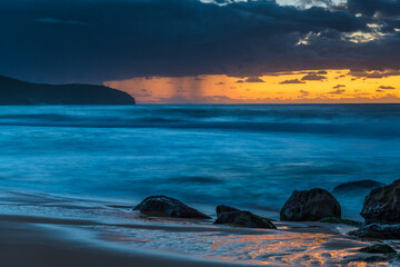 Sunrise seascape with rain clouds on the horizon