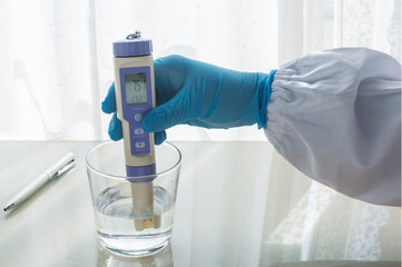 Hand holding an PH meter. Checking the  potential of hydrogen of water